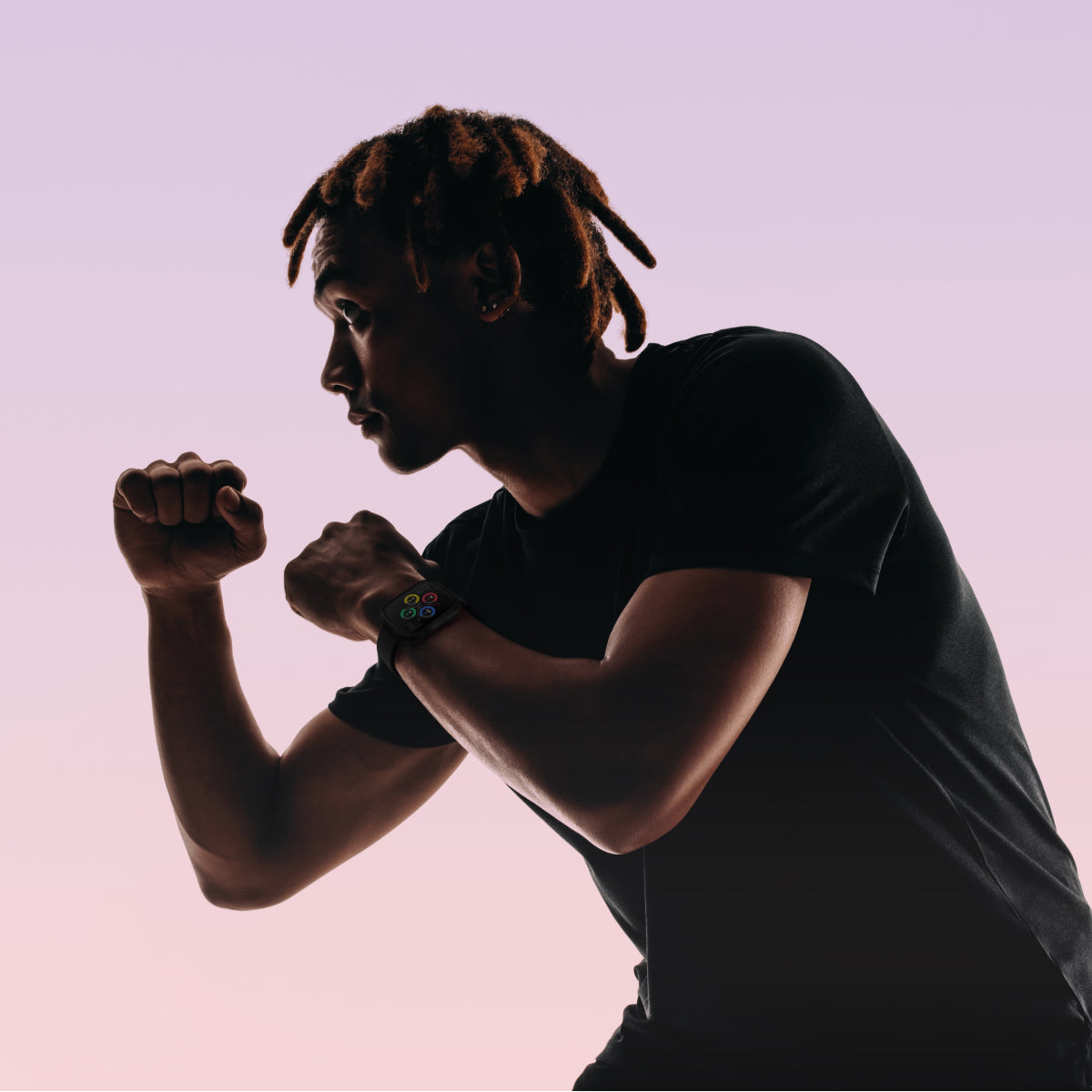 Silhouette of a person wearing a black shirt against a pink background and a air 5  pro smartwatch