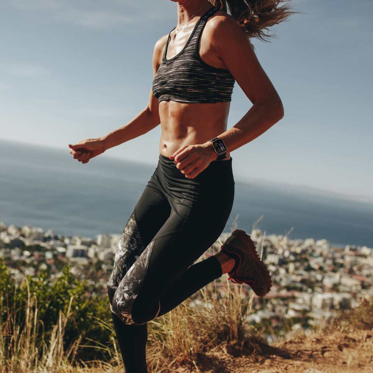 woman running wearing smartwatch